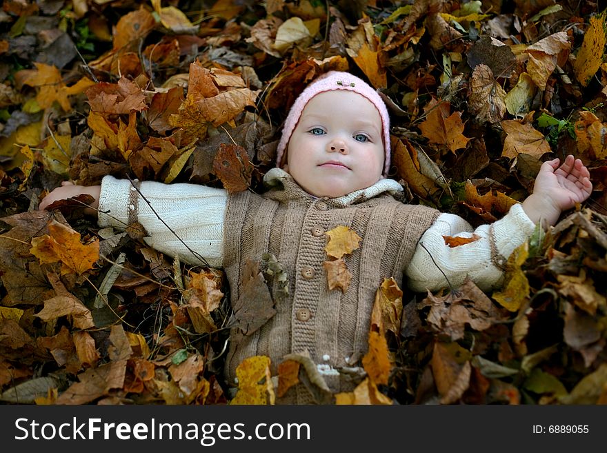 An image of little girl with yellow leaves in autumn park. An image of little girl with yellow leaves in autumn park
