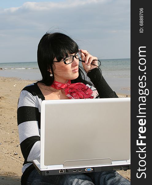 Young woman working with computer at the beach