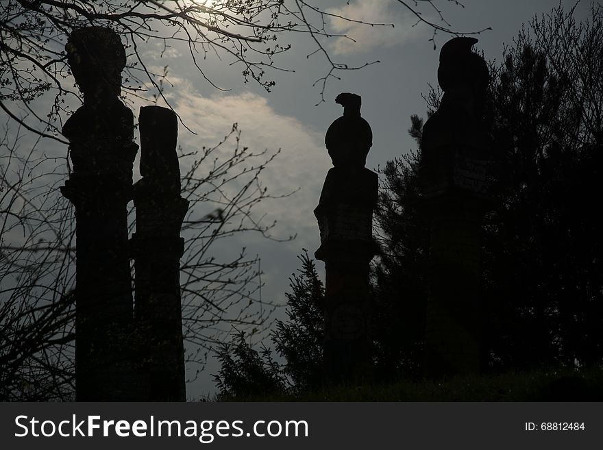 It is sunset. Four mysterious figures standing in the park. They Ð°re mounted on the pillars. It is sunset. Four mysterious figures standing in the park. They Ð°re mounted on the pillars.