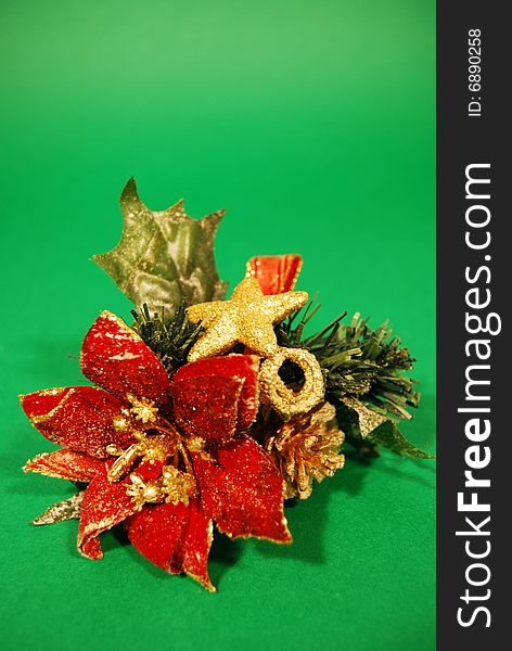 A christmas decoration with a red flower and a golden star on a green background