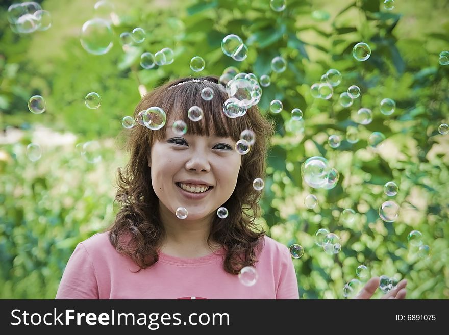 A girl is smiling with Many beautiful soap bubble. A girl is smiling with Many beautiful soap bubble