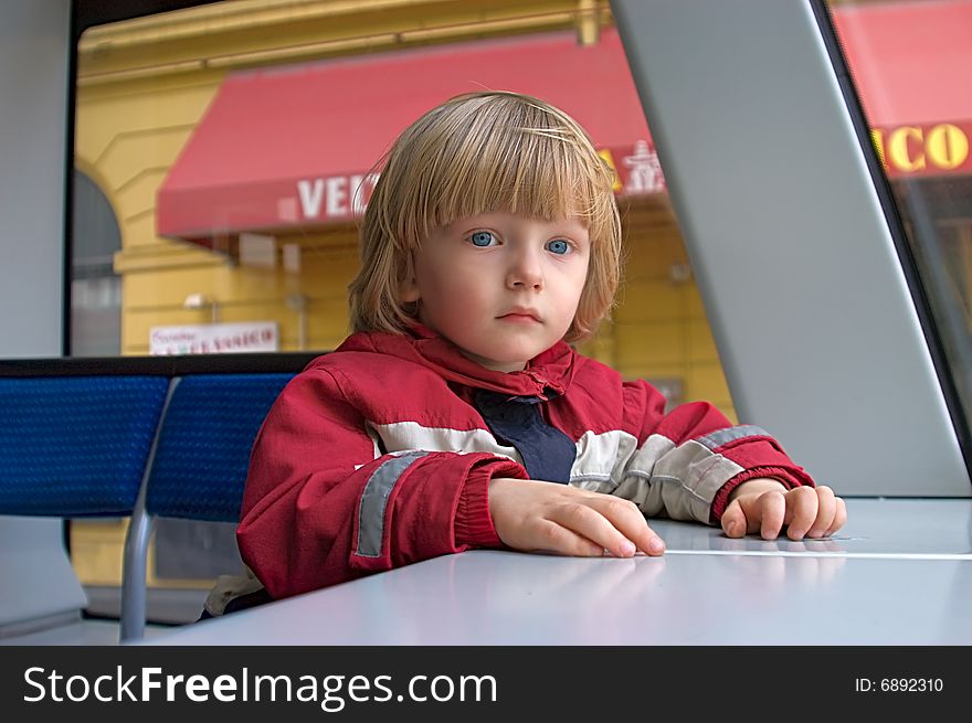 Little boy sits in street railway