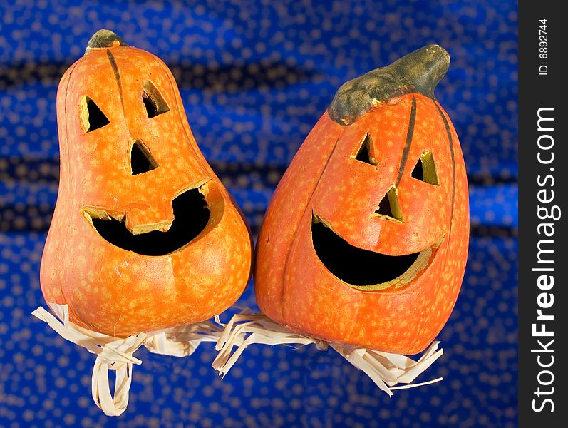 Two funny Halloween pumpkins on glittering blue background. Two funny Halloween pumpkins on glittering blue background