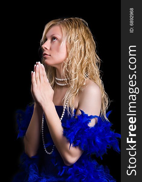 Beautiful girl in a dark blue dress prays