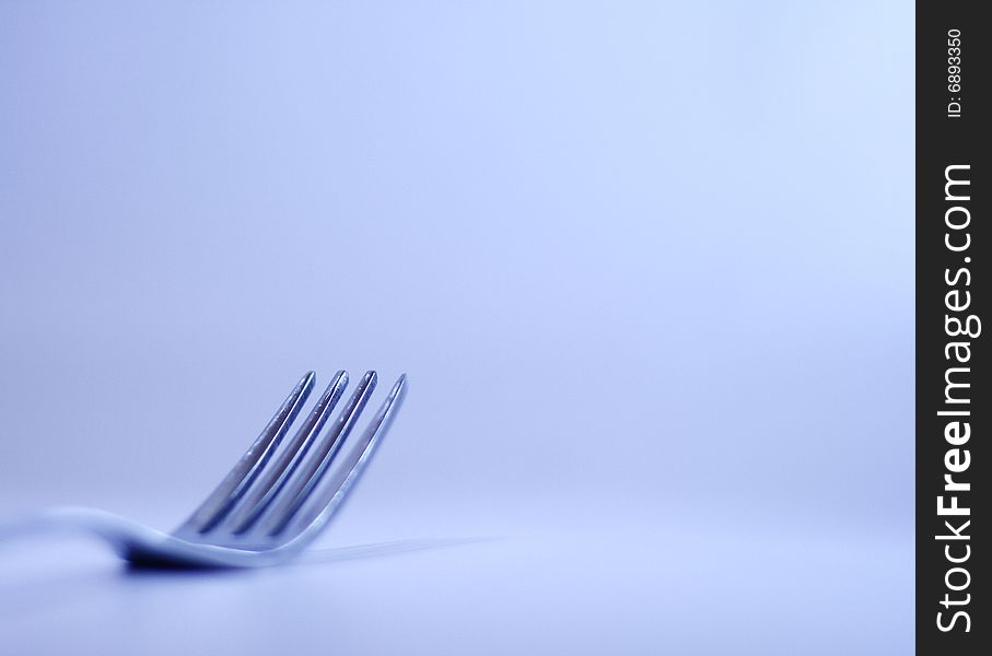 Eating silver fork with blue light background