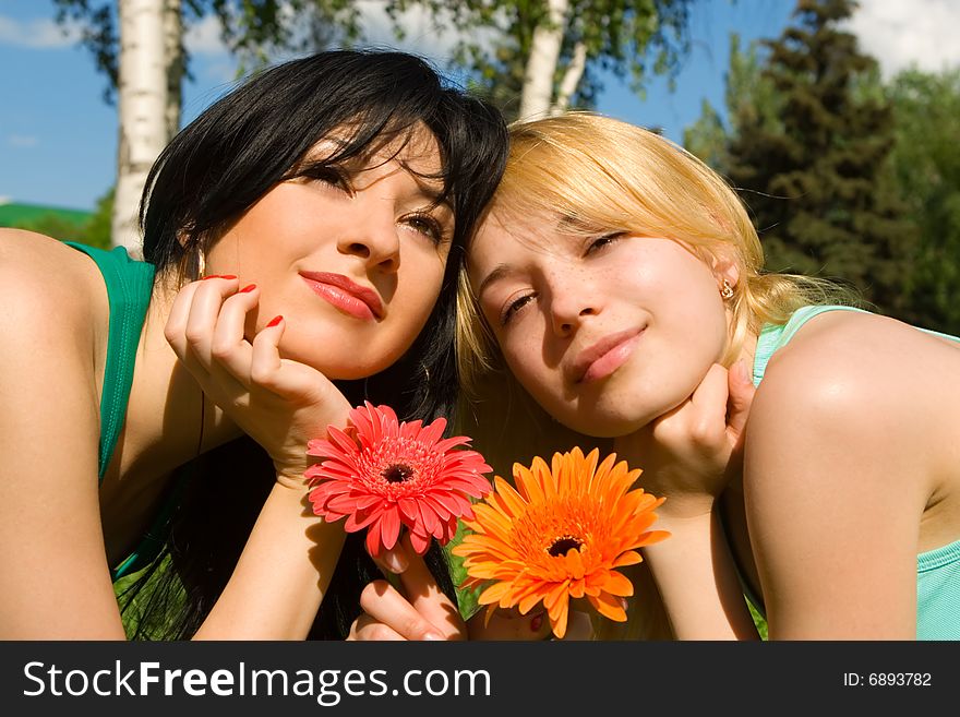 Pretty women rest in the park with flowers
