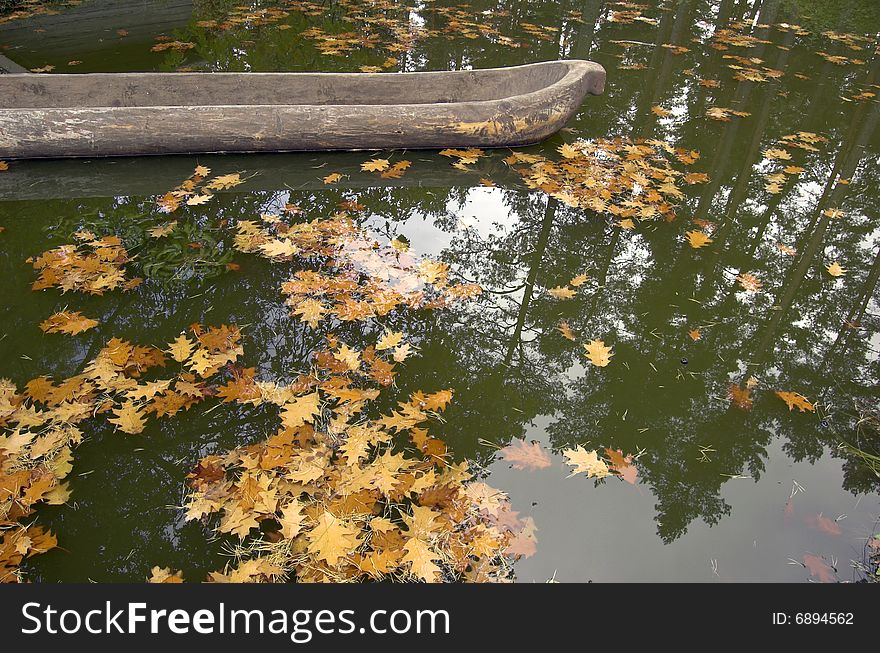 Old wooden shuttle in lake with yellow leaves. Old wooden shuttle in lake with yellow leaves.