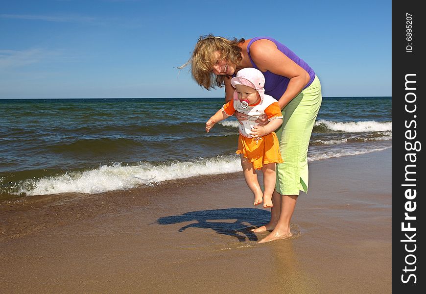 Mother with daughter are playing on the beach. Mother with daughter are playing on the beach