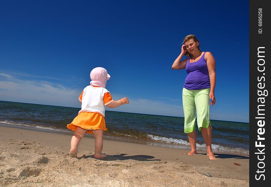 Mother with her daughter is playing on the beach. Mother with her daughter is playing on the beach