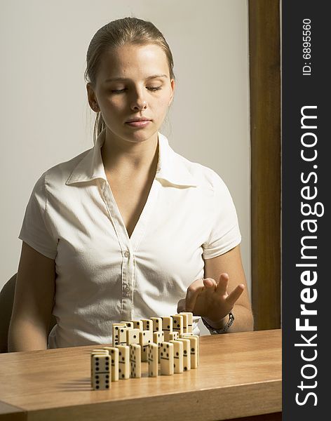 Woman looking thoughtful while playing dominos. Vertically framed photo. Woman looking thoughtful while playing dominos. Vertically framed photo.