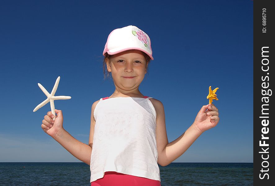 Girl with two small starfishes. Girl with two small starfishes