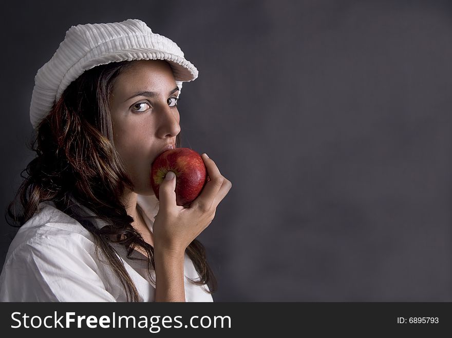 Beautiful young woman eating red apple