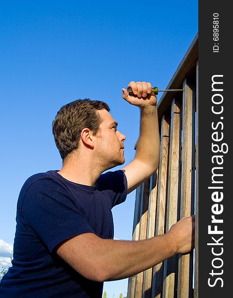 Man using screwdriver to fix porch. Vertically framed photo. Man using screwdriver to fix porch. Vertically framed photo.