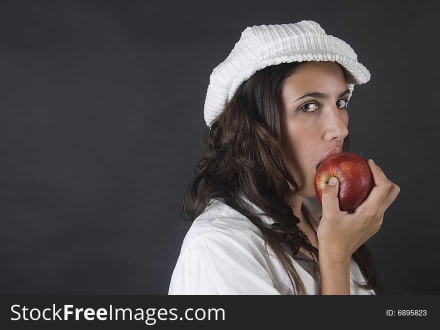 Beautiful young woman eating red apple