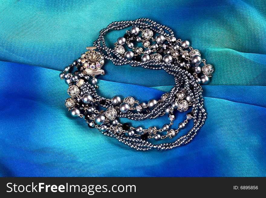 Silver imitation jewelry on light coloured fabric