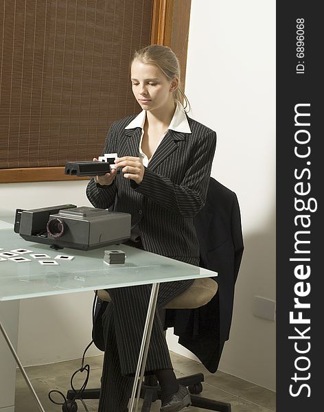 Woman  placing slides in  a slide show projector. Vertically framed photo. Woman  placing slides in  a slide show projector. Vertically framed photo.