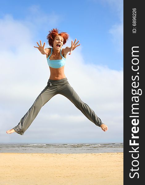 Happy jumping girl on the beach