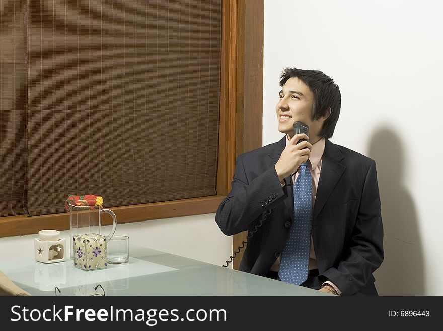 Smiling man in a suit shaving as he sits at a table with a pitcher and a candle on it. Horizontally framed photo. Smiling man in a suit shaving as he sits at a table with a pitcher and a candle on it. Horizontally framed photo.