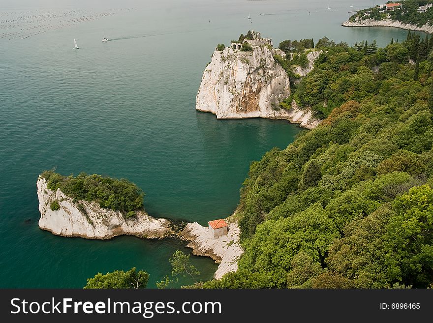 View on ruins on rocks above the sea from castle Duino, Italy. View on ruins on rocks above the sea from castle Duino, Italy.