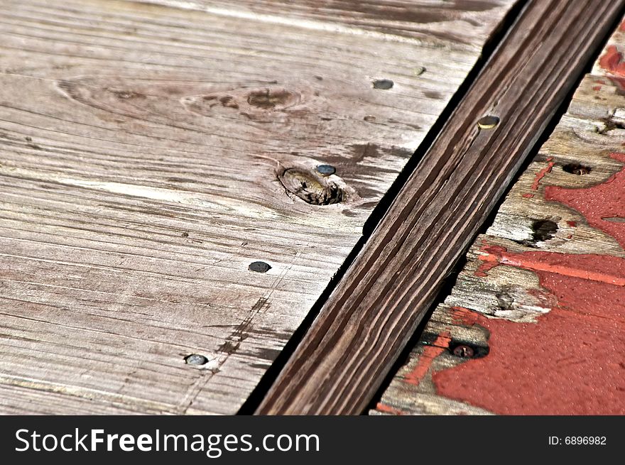 Distressed wooden planks of deck worn and painted in bright sunlight. Distressed wooden planks of deck worn and painted in bright sunlight