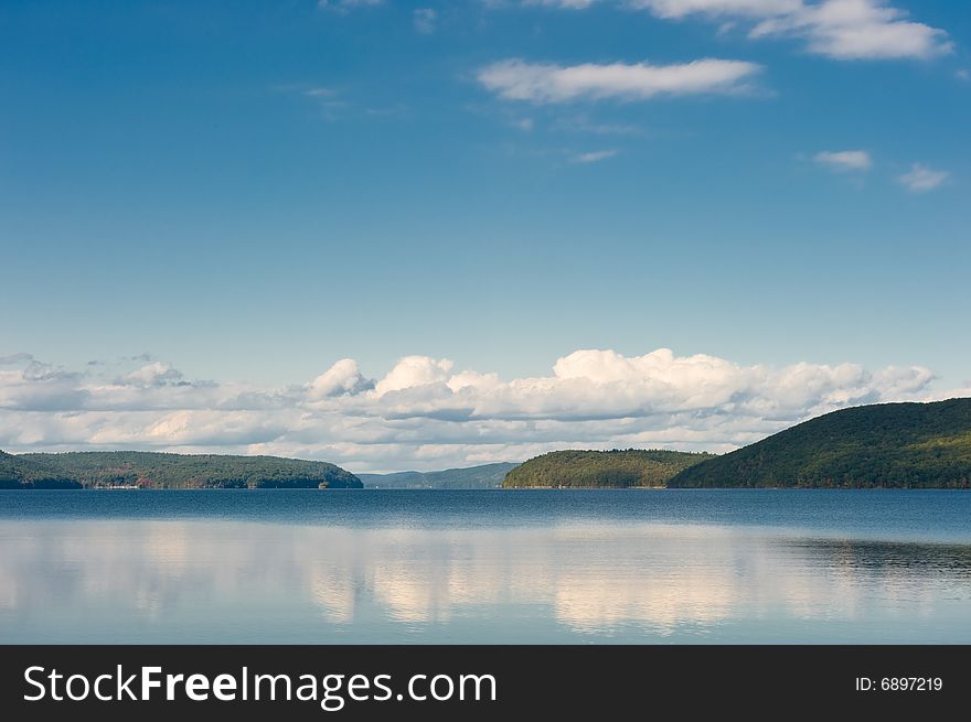 Clouds and the sky are reflected in lake water. Clouds and the sky are reflected in lake water