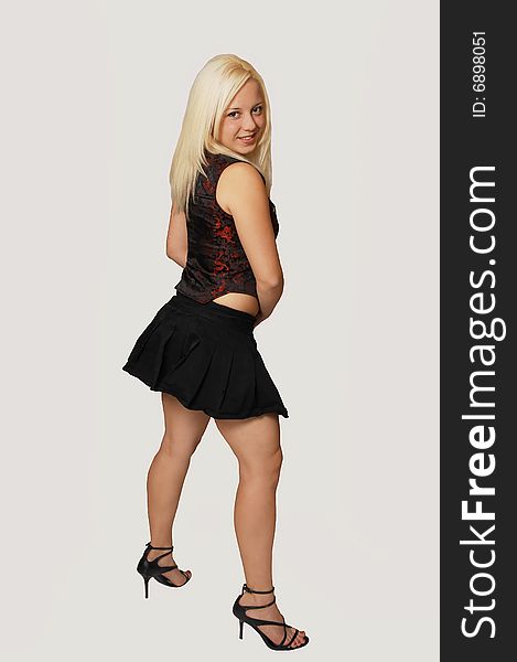 A young pretty woman standing in a mini skirt and having fun, for white background and shooing her great figure. A young pretty woman standing in a mini skirt and having fun, for white background and shooing her great figure.