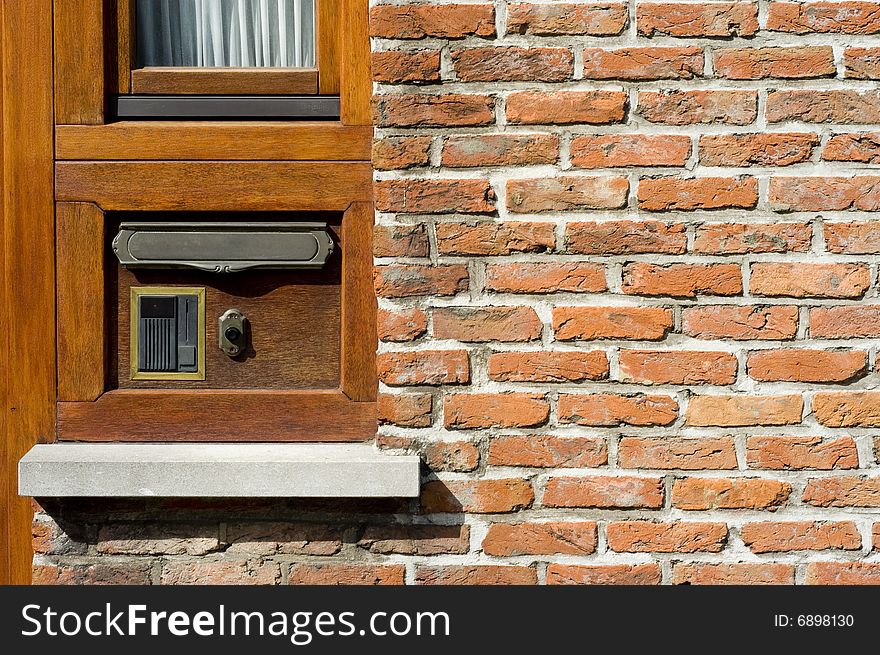 Wall with wooden section, door bel, postal slot, window