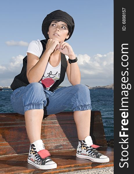 Rebel young woman sitting near the sea