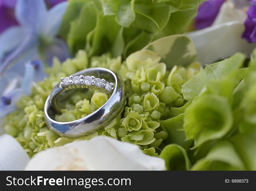 Closeup of wedding rings on bouquet DOF focus on diamonds