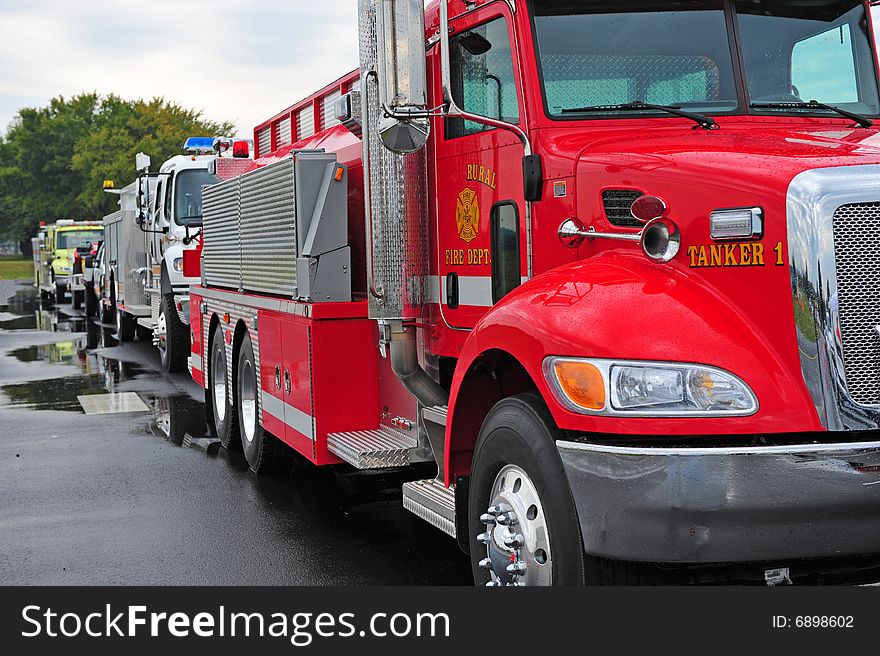 Row of rescue vehicles with red fire truck in front