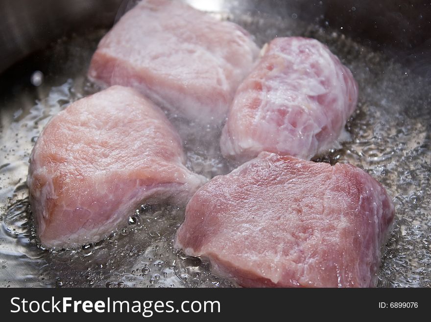 Fresh pork at the time of frying in hot oil. Fresh pork at the time of frying in hot oil