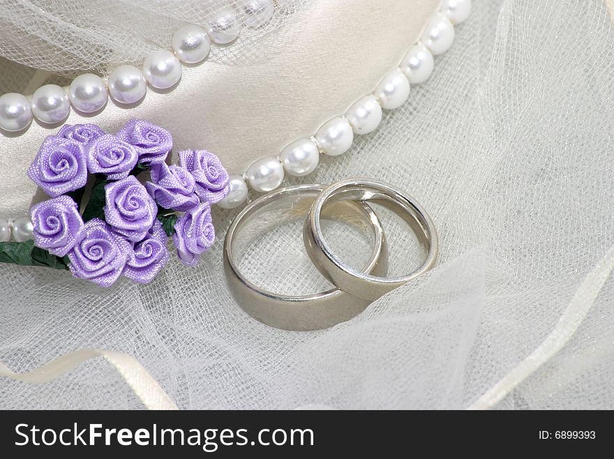 Wedding bands on veil with purple flowers. Wedding bands on veil with purple flowers