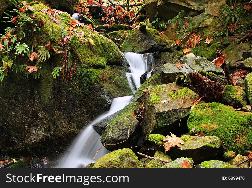 A waterfall drops down through mossy boulders in Squamish, British columbia. A waterfall drops down through mossy boulders in Squamish, British columbia.