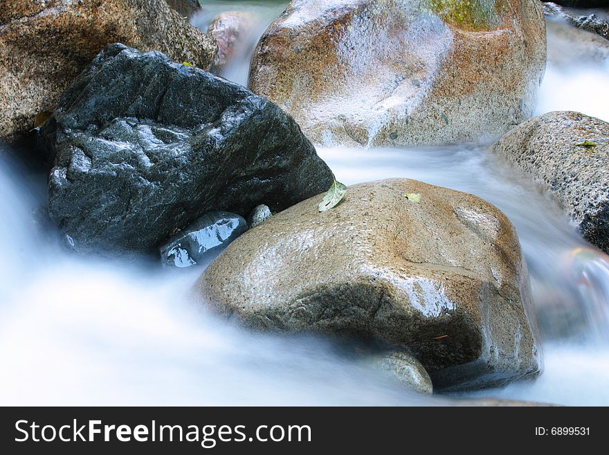 Silky water flows through damp boulders in Squamish, BC.