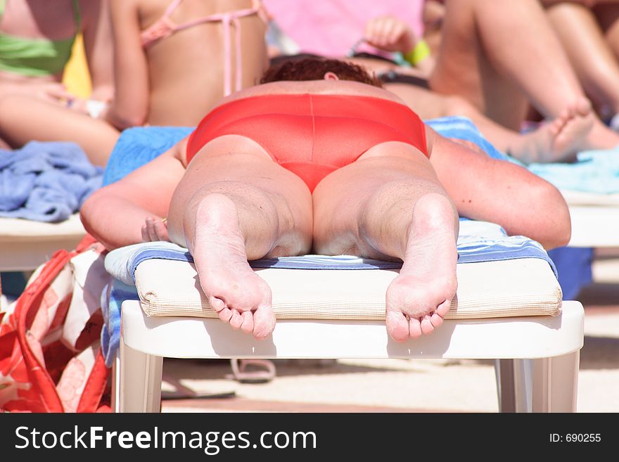 Adult woman on a deckchair having sunbathe