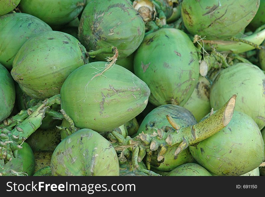 A pile of fresh green coconuts