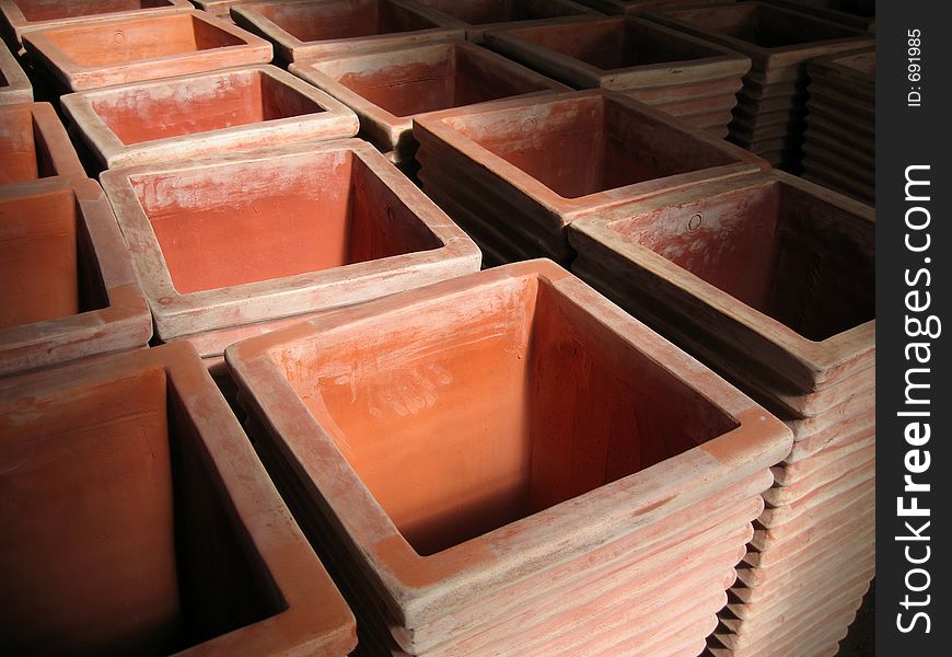 Rows of tall rectangular terracotta pots. Rows of tall rectangular terracotta pots.