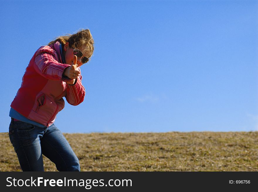 Young girl dressed magenta jacket and jeans playing around meadow with clean sky as background. Young girl dressed magenta jacket and jeans playing around meadow with clean sky as background