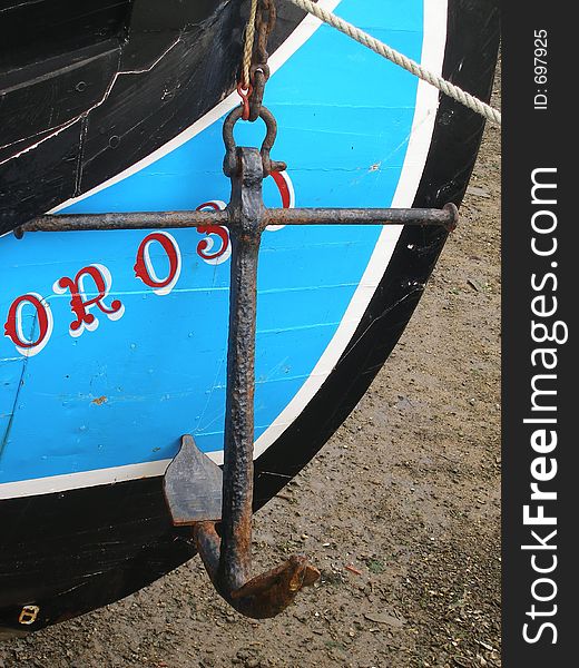 Colorful wood boat with its anchor hanging. Colorful wood boat with its anchor hanging