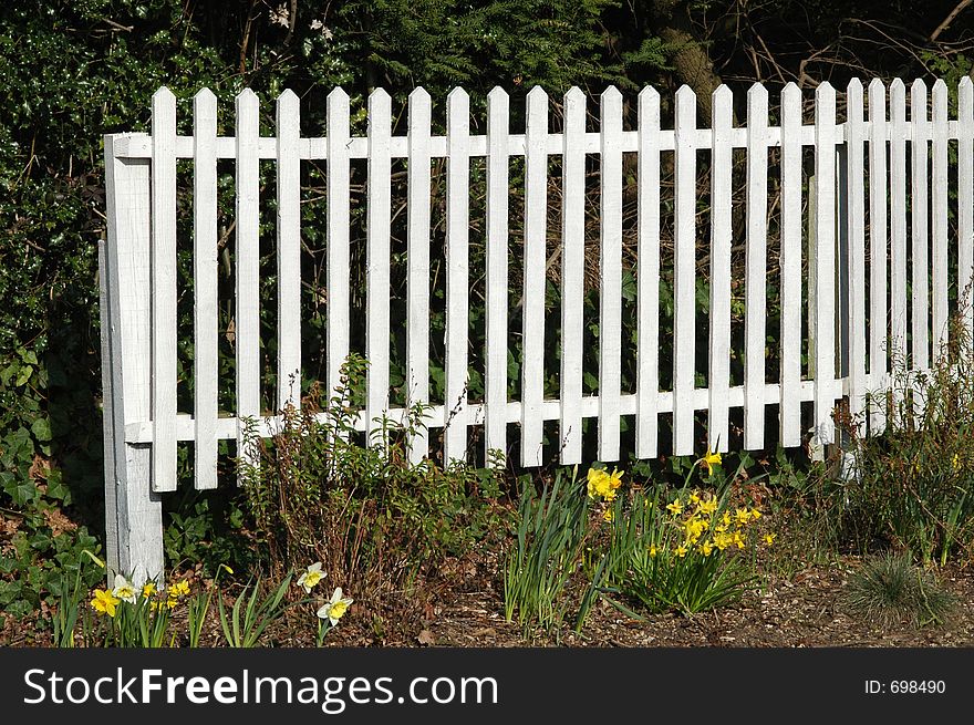 White picket fence and flower bed