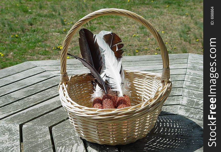 Basket of indian corn and turkey feathers in a wickered basket. Basket of indian corn and turkey feathers in a wickered basket.