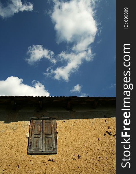 Old window against deep blue sky with clouds. Old window against deep blue sky with clouds