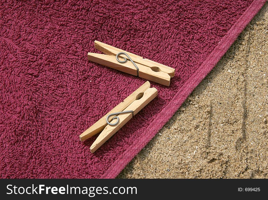 Clothes pegs on sand on towel. Clothes pegs on sand on towel