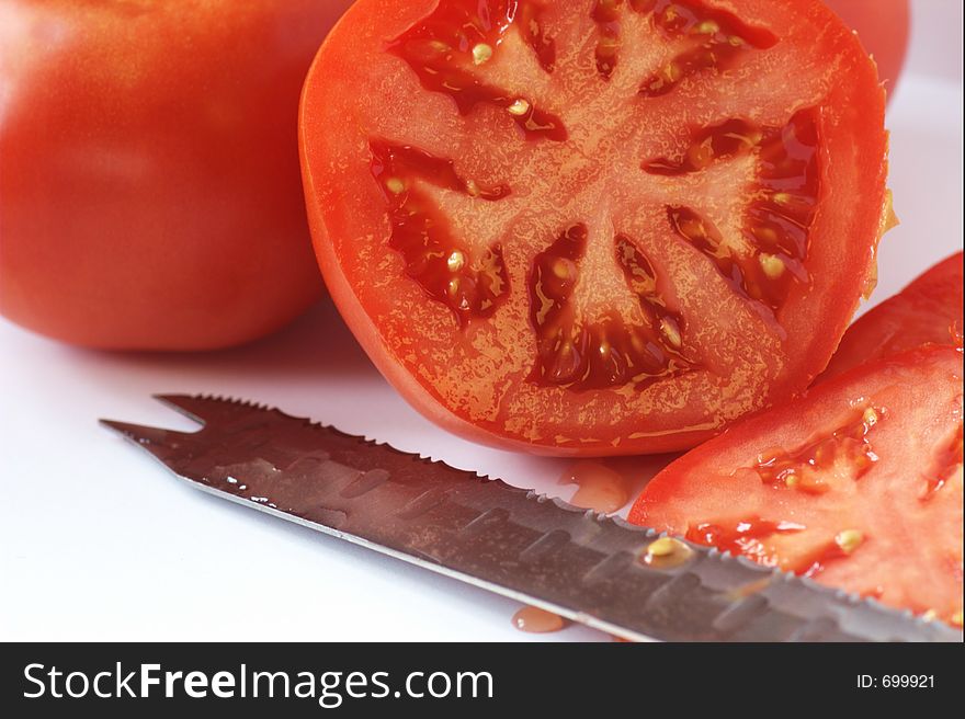 Sliced garden fresh tomatoes with a serrated knife. Sliced garden fresh tomatoes with a serrated knife.