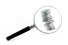 Magnifying Glass With A Column Of Coins Behind Royalty Free Stock Photos