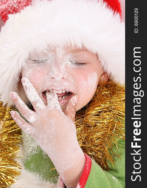 Toddler wearing a christmas hat, baking christmas cookies