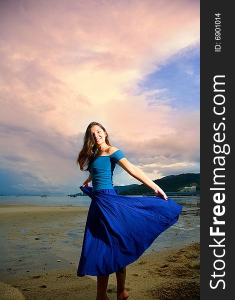 Young eurasian woman at the sunset beach