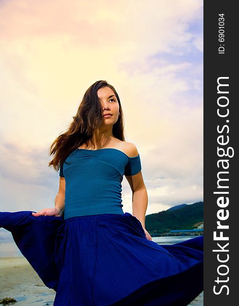 Young eurasian woman at the sunset beach