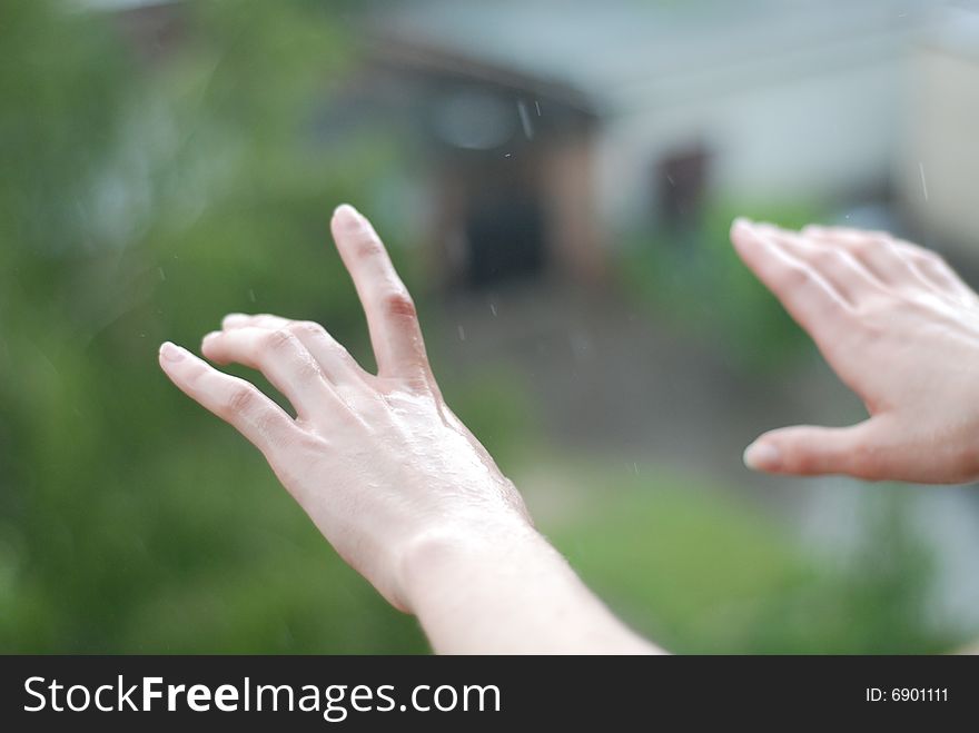 The raindrops falling on the woman's hands. The raindrops falling on the woman's hands