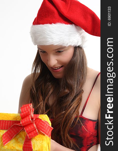 Young girl in santa's cap holds the christmas present. Young girl in santa's cap holds the christmas present